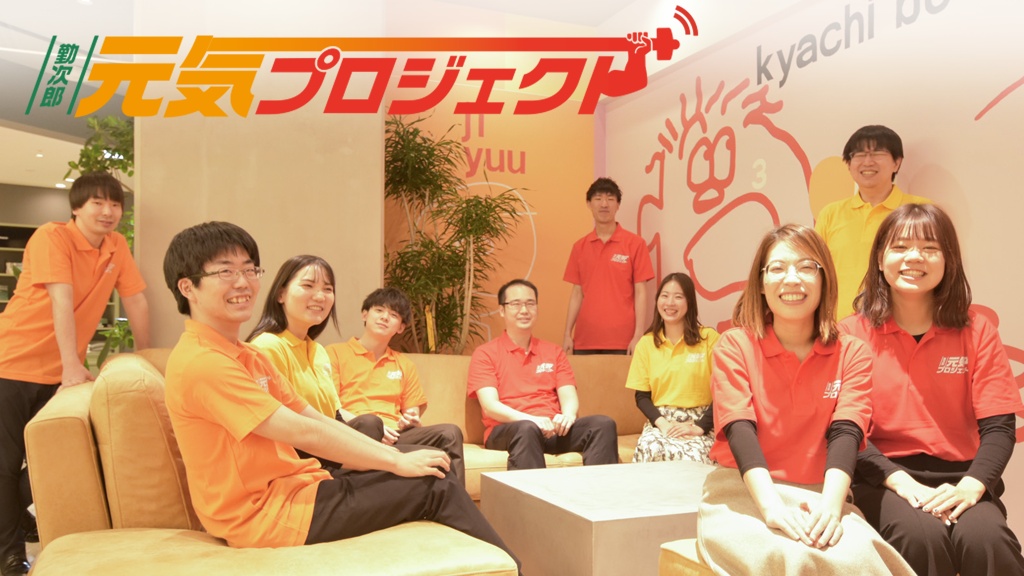 Kinjiro Genki Project team members wearing orange, red and yellow shirts in a company lounge