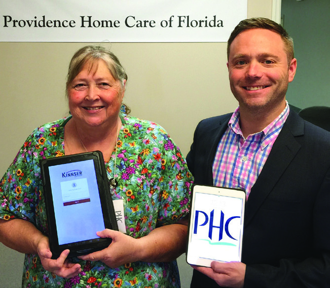 Nurse Arlene Davis and Providence partner David McElwee holding tablets