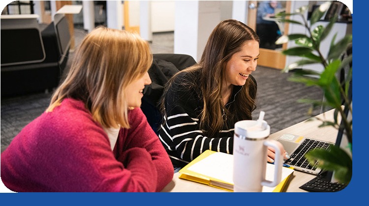 Two Kipsu team members working together at a laptop in the Minneapolis office