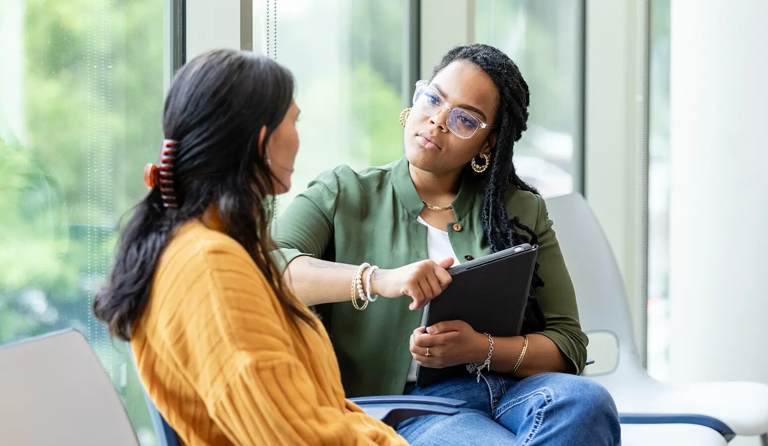 A behavioral-health professional listens to a patient while holding a tablet