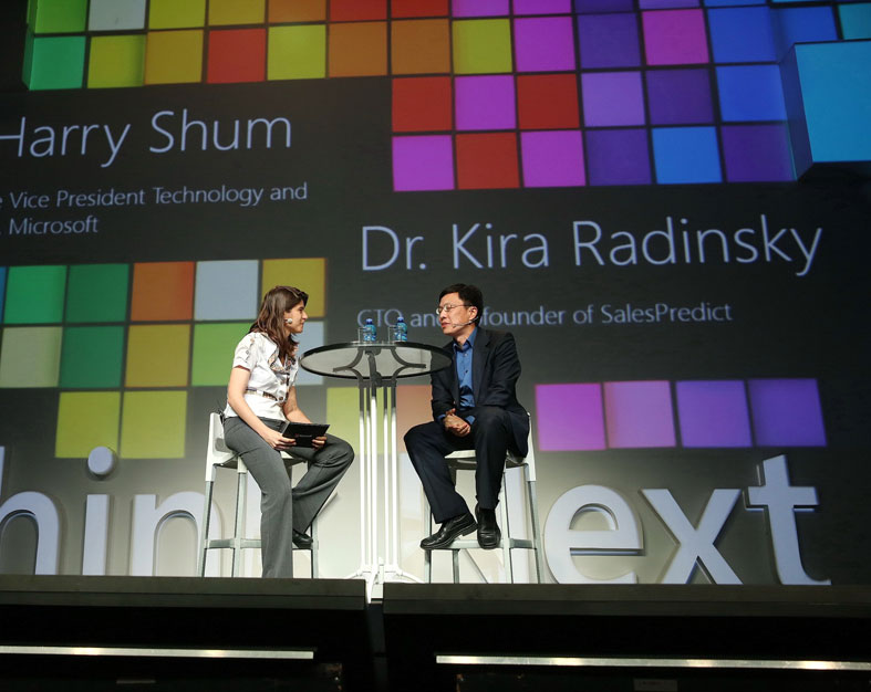 Kira Radinsky and Harry Shum seated on stage at a Microsoft event