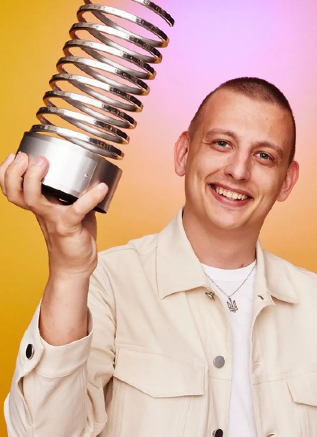 Kirill Lazarev smiling and holding a spiral-shaped Webby trophy