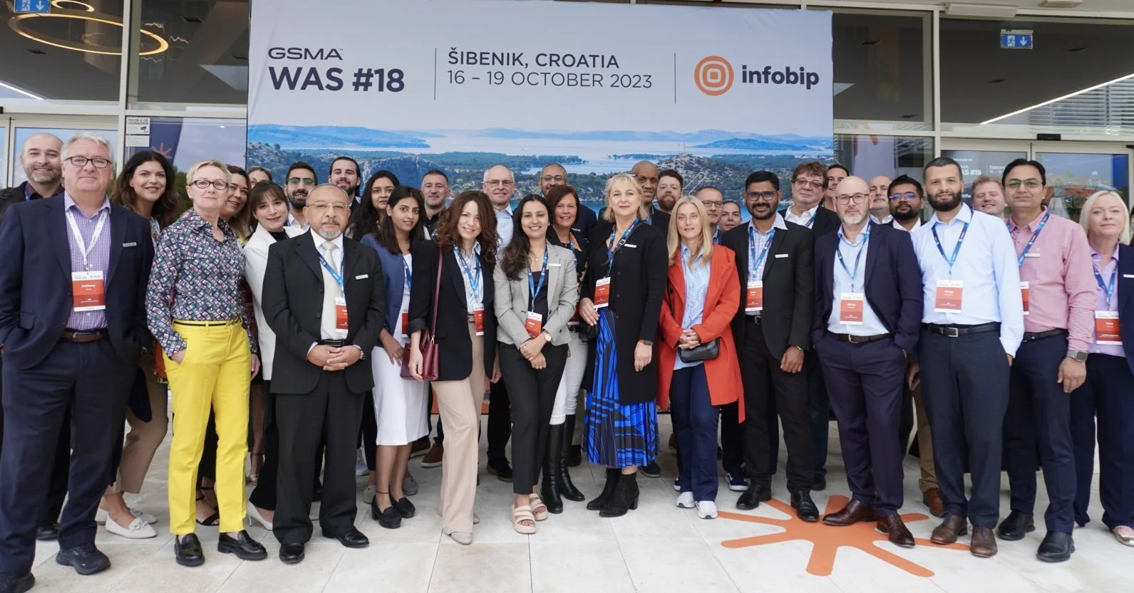 Nextgen Clearing colleagues gathered beneath the GSMA WAS number 18 sign in Šibenik, Croatia