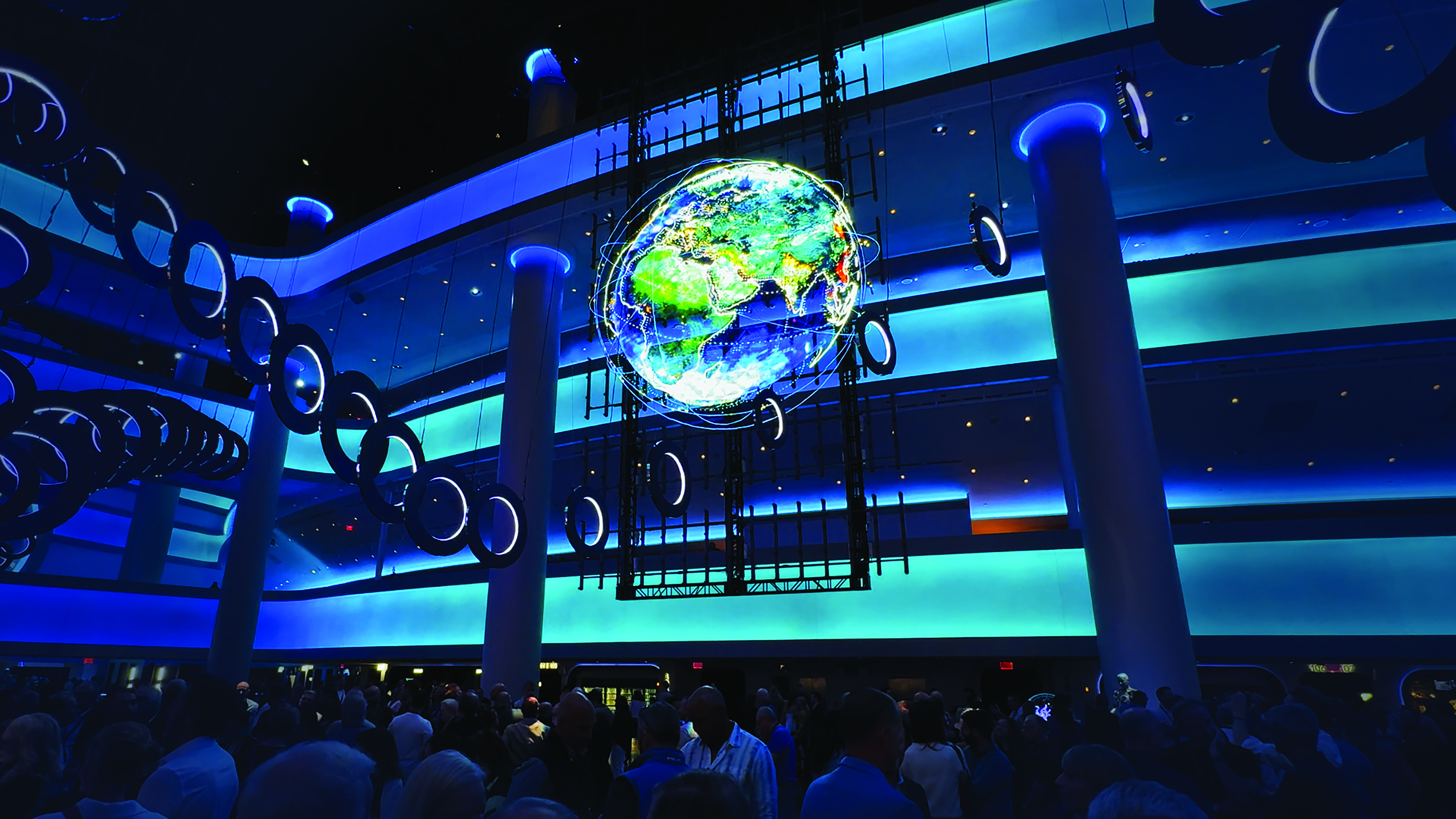 A glowing digital globe on HYPERVSN’s display wall above visitors in the Sphere atrium