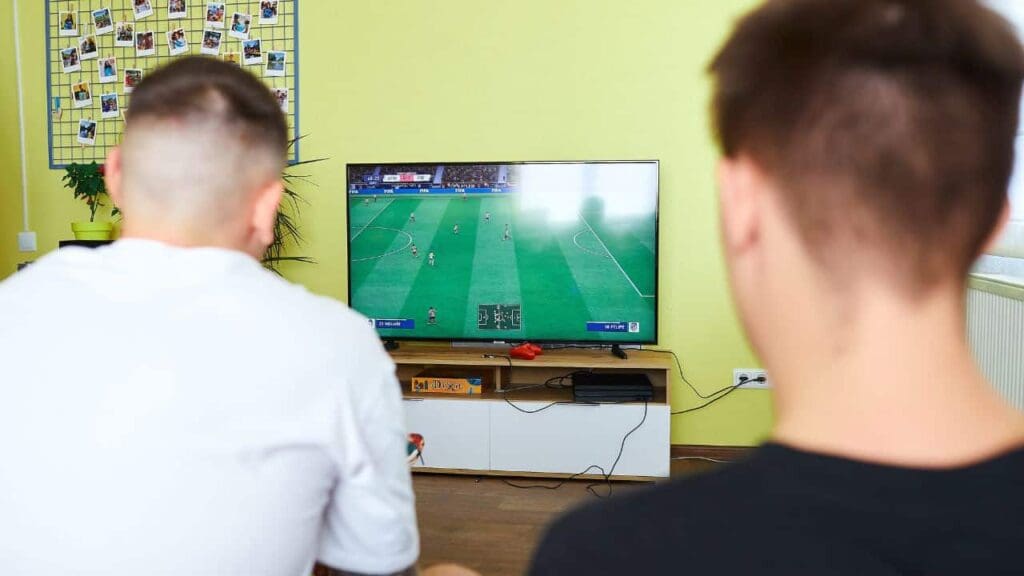 Two Kitrum team members playing a football video game in an early Kharkiv office