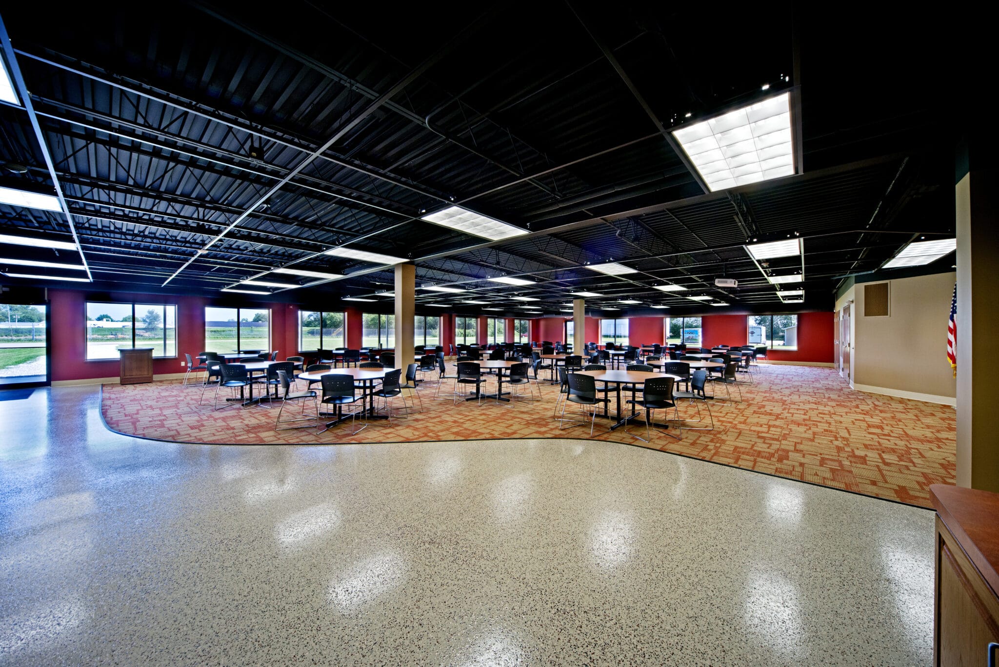 Renovated KMC Controls employee breakroom with tables, chairs and an open ceiling