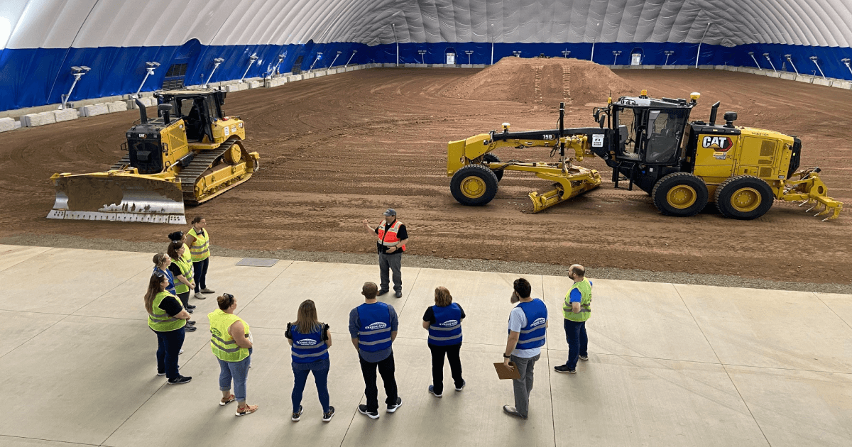 People in safety vests gathered for instruction inside the Knife River training dome