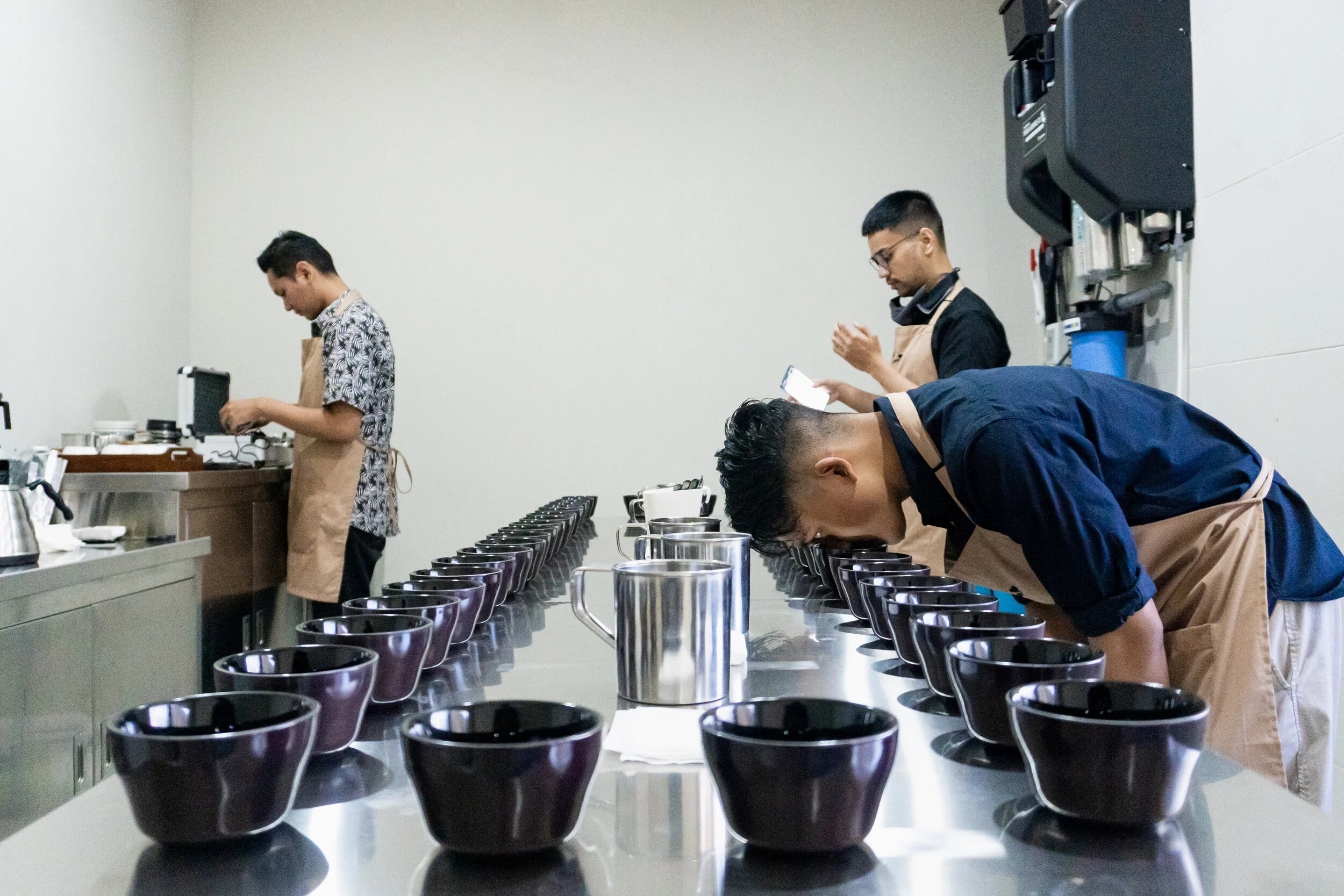 Kenangan Academy trainees examining rows of coffee samples