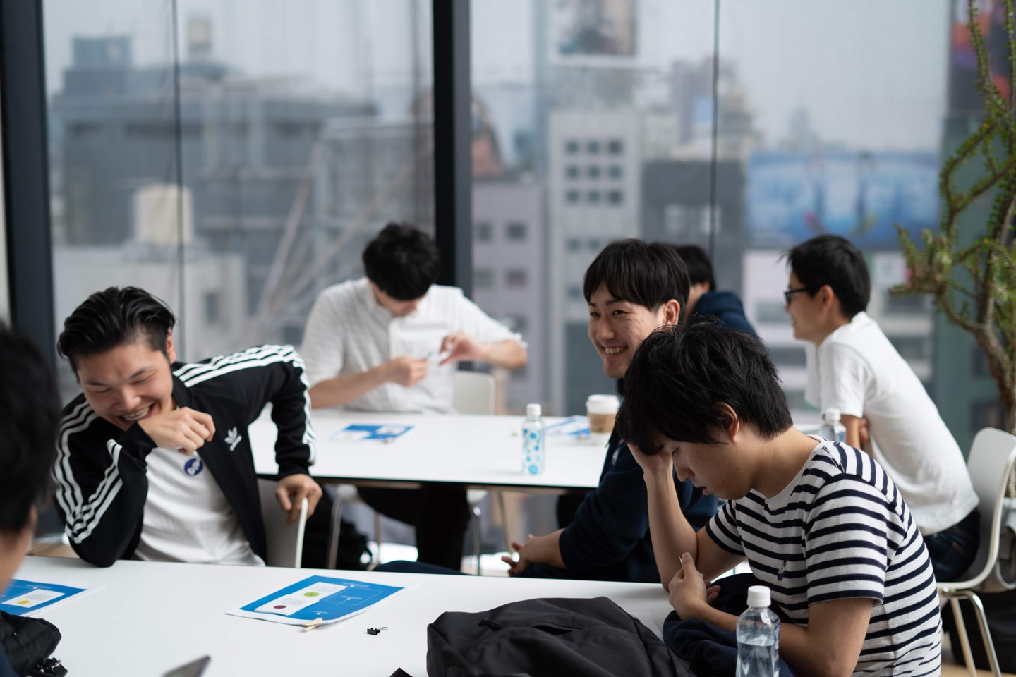 An early Ubie team gathering around tables, with colleagues laughing and talking