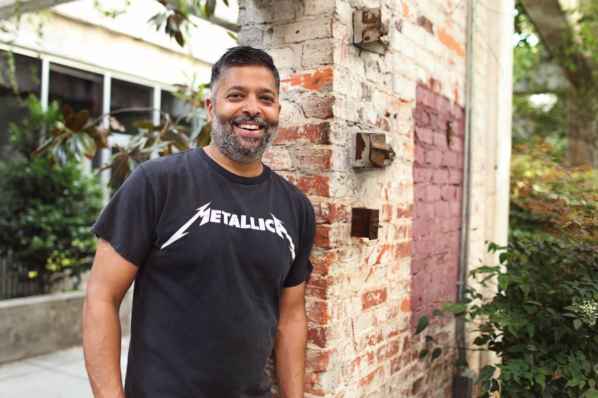KP Reddy smiling outdoors beside a brick wall, wearing a Metallica T-shirt