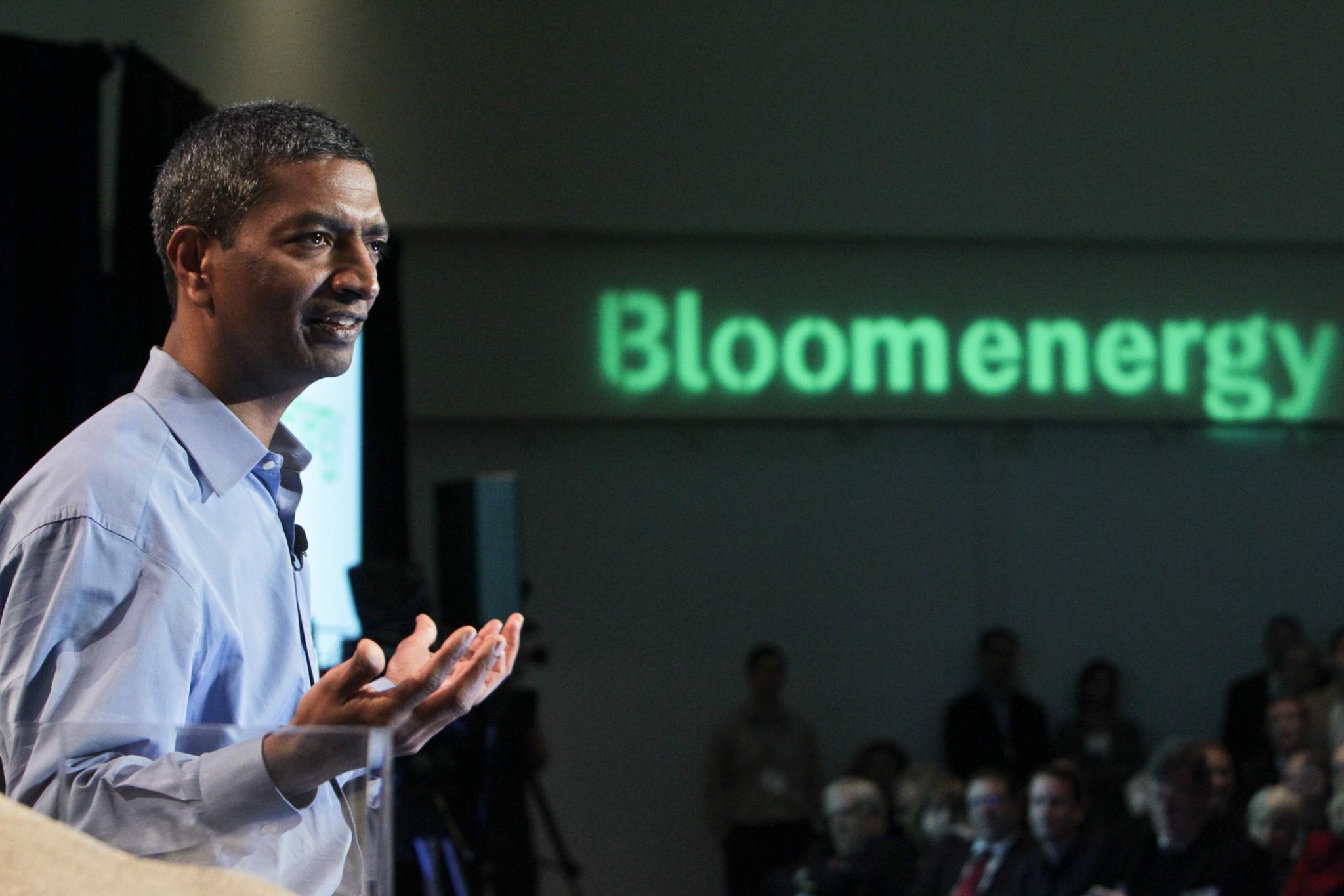 KR Sridhar gestures while speaking at Bloom Energy's February 24, 2010 launch, with the company name illuminated behind him.