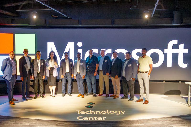 Group gathered in front of the Microsoft sign at the AI Insider Forum in Detroit