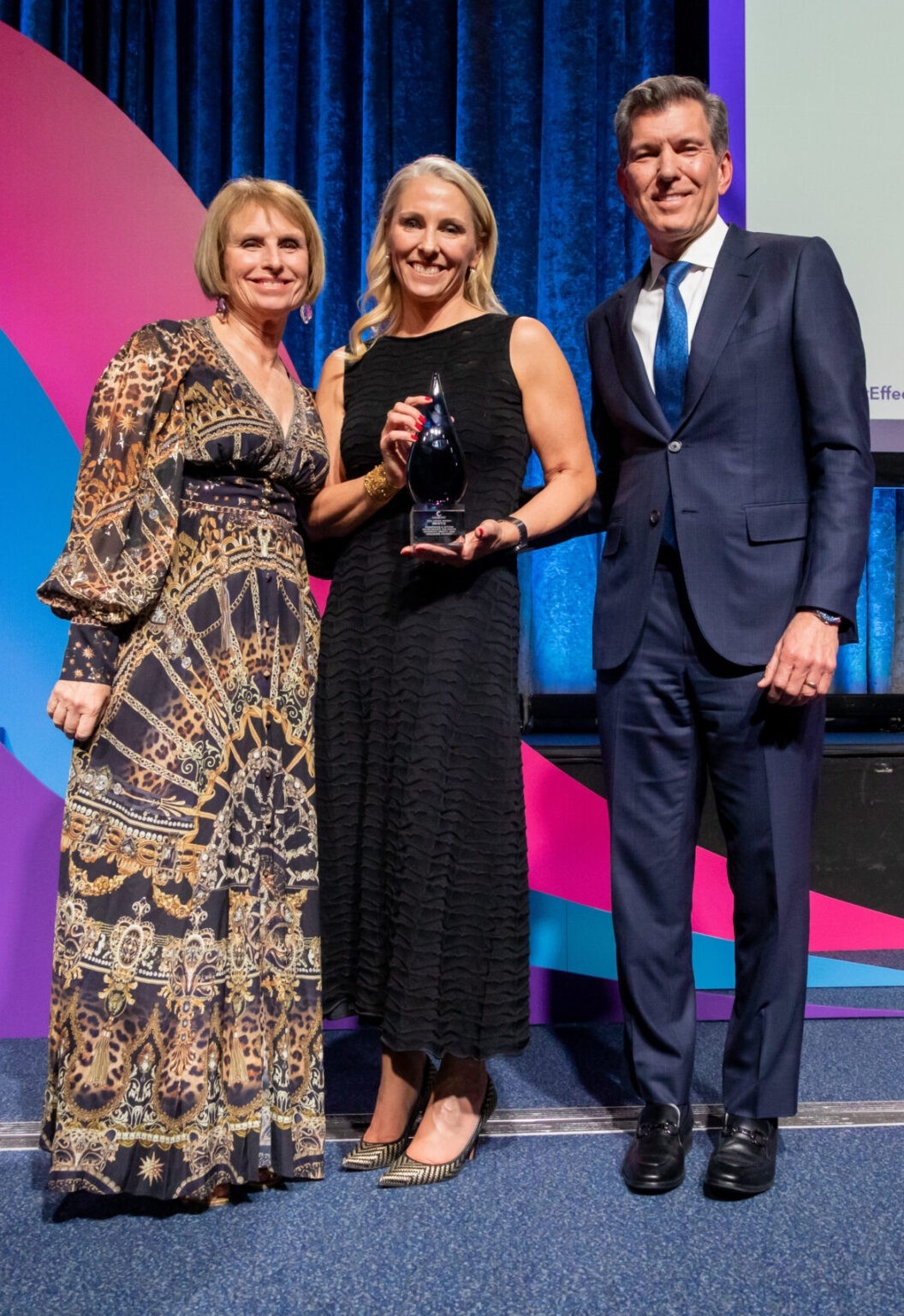 Kristin Peck, center, holding the 2024 Catalyst Award with Lorraine Hariton and Paul Knopp