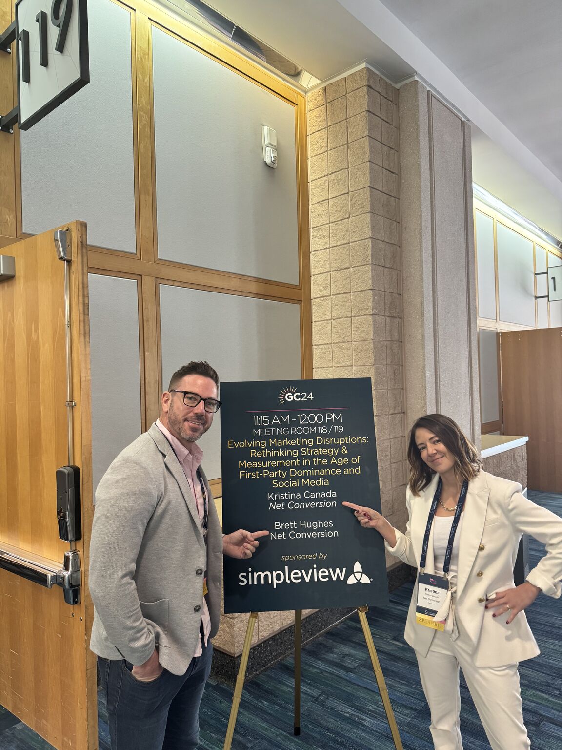 Kristina Canada and Brett Hughes beside the sign for their marketing disruptions session at the 2024 Florida Governor's Conference on Tourism
