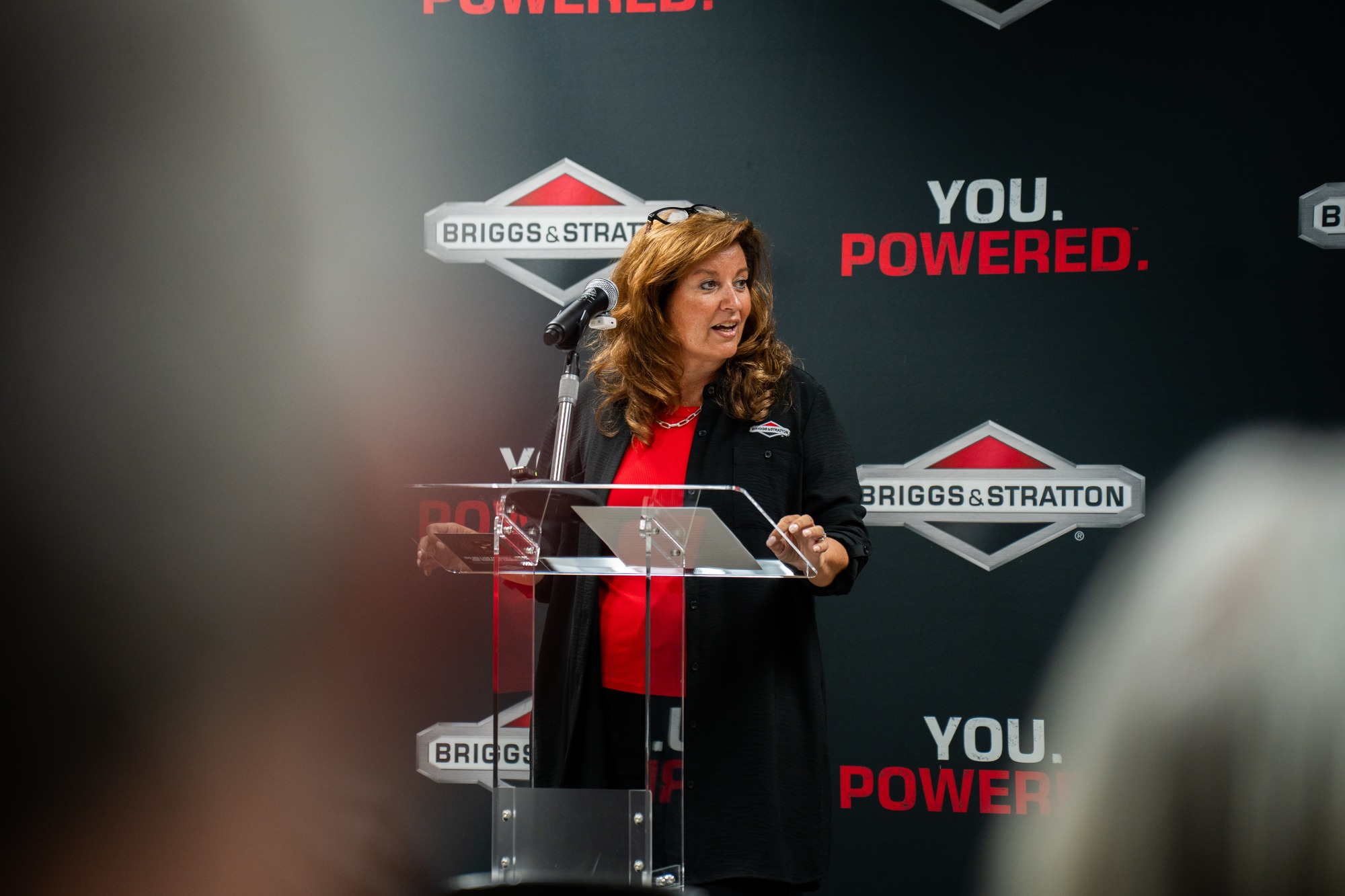 Kristina Cerniglia speaking at a lectern during the Poplar Bluff engine production celebration