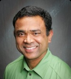 Kumar Ganapathy in a green shirt, photographed for his Calient advisory profile