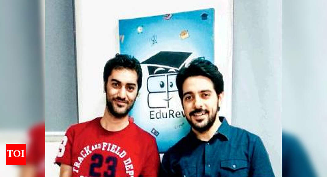 Hardik Dhamija and Kunaal Satija standing beside an EduRev poster