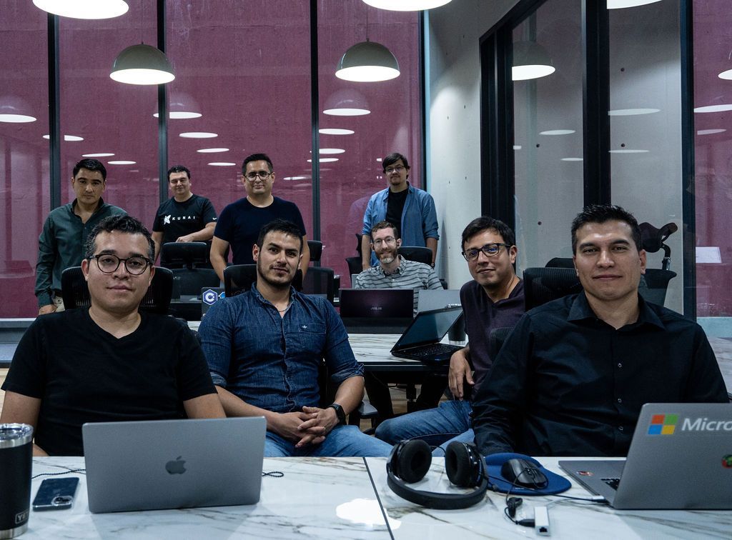 Kunai team members gathered around laptops in a meeting room
