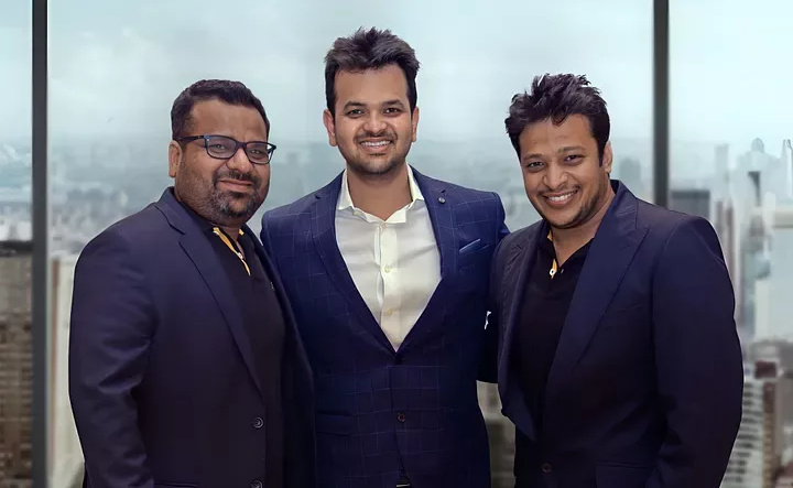 FarEye’s three co-founders standing together by an office window