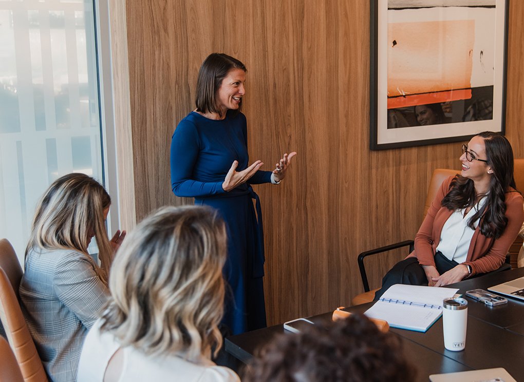 Kelly Voelker speaking with colleagues around a conference table