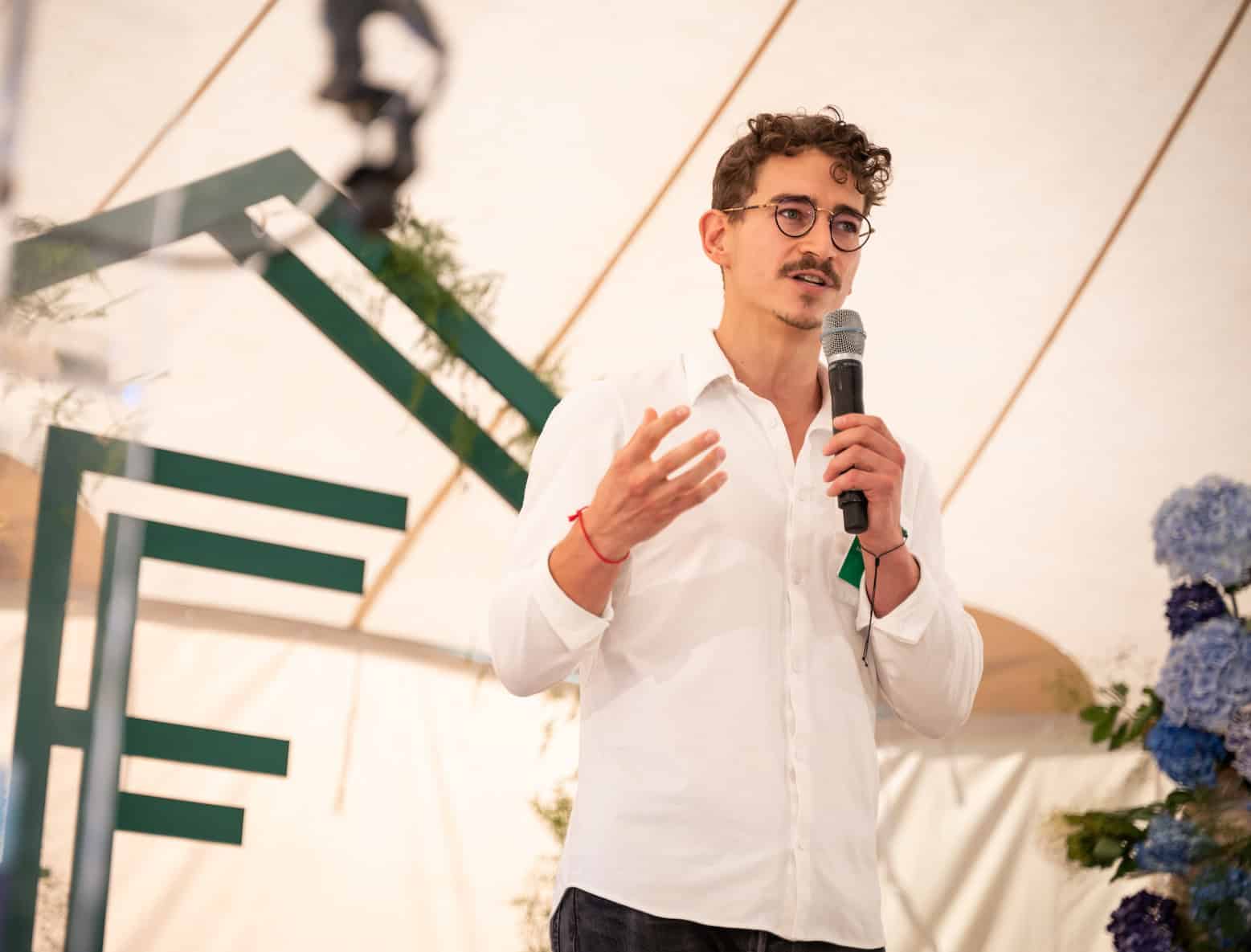 Kylan Gibbs speaking into a microphone at Founders Forum in 2023