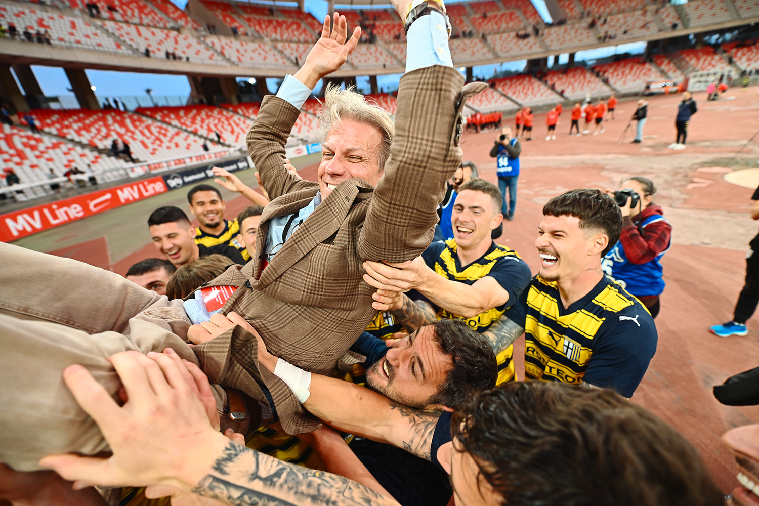 Parma players lift a smiling Kyle Krause into the air after securing promotion on May 1, 2024