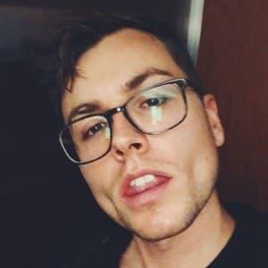 An informal close-up of Kyle Kuhns wearing glasses
