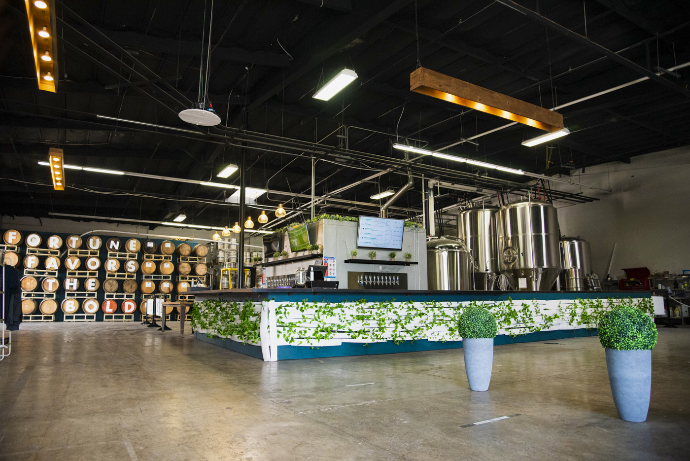 The Embolden and New Motion tasting room with brewing tanks behind the bar