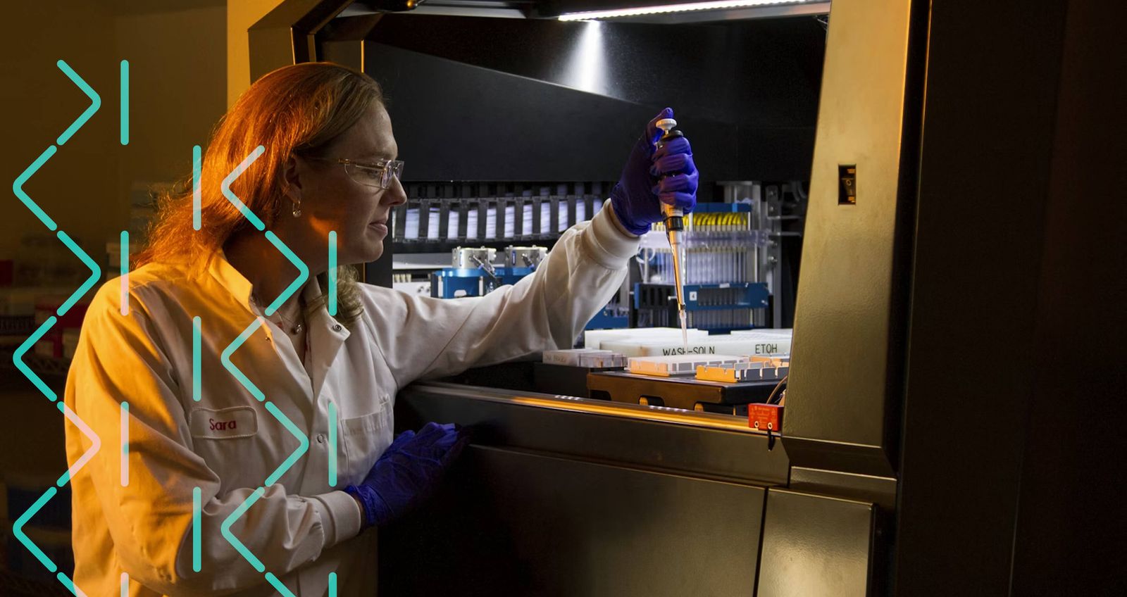 A scientist in a lab pipetting samples into an automated instrument