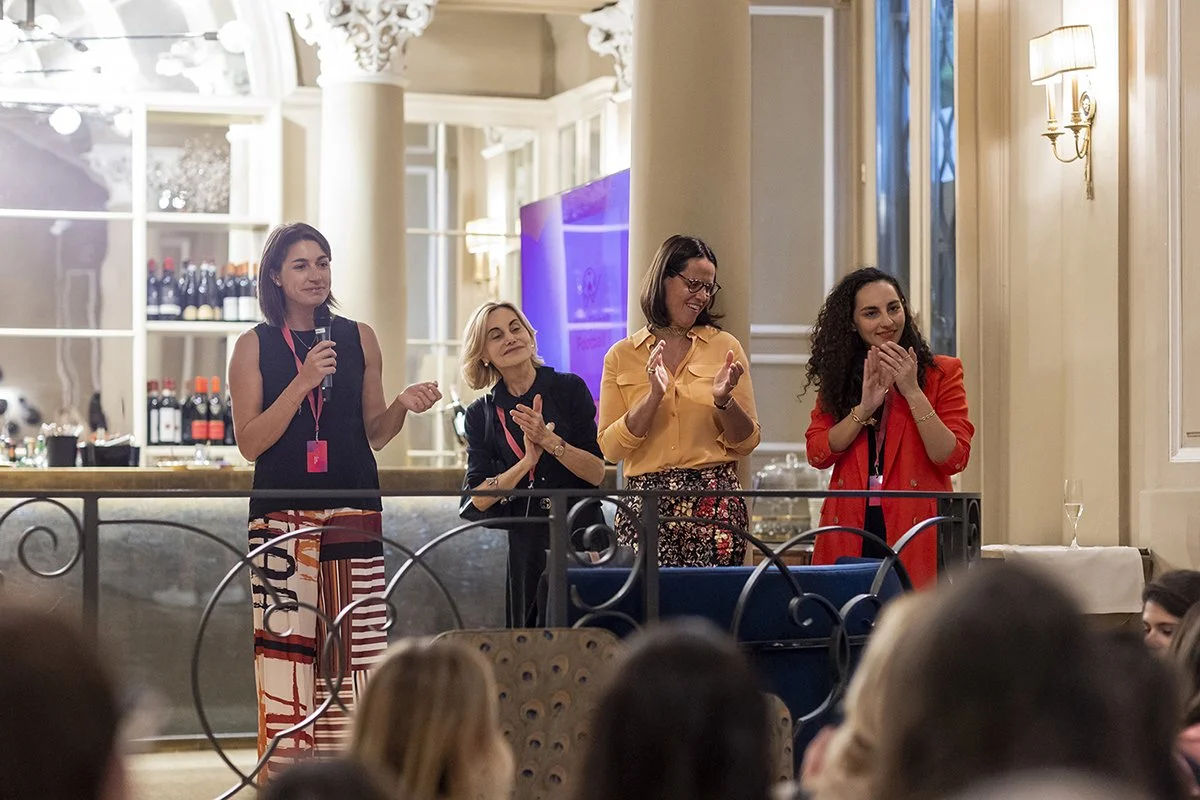 Four women speaking and applauding at a La Carica delle 101 event