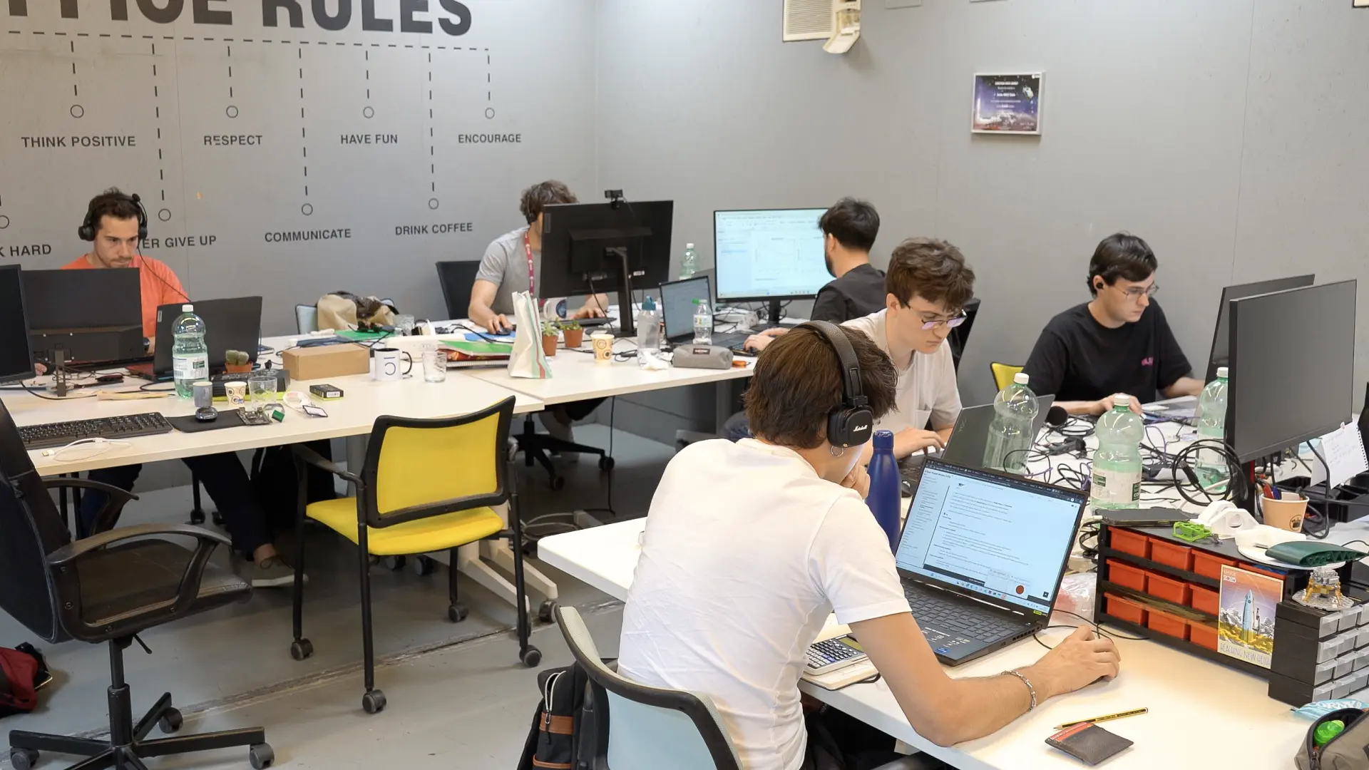 Entrepreneurs working on laptops in a shared workspace at La Nave