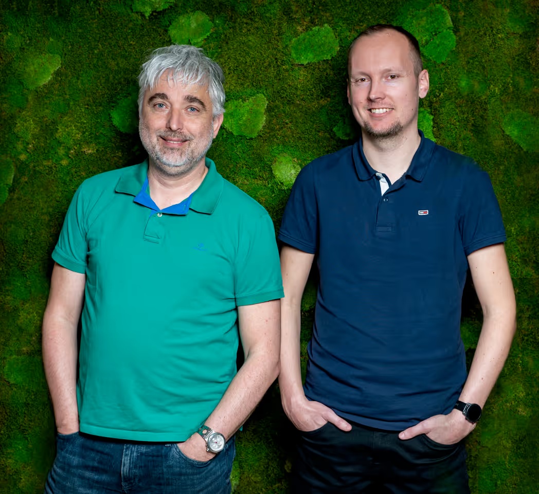 Product Fruits co-founders Karel Papík on the left and Ladislav Šalom on the right, standing in front of a green wall