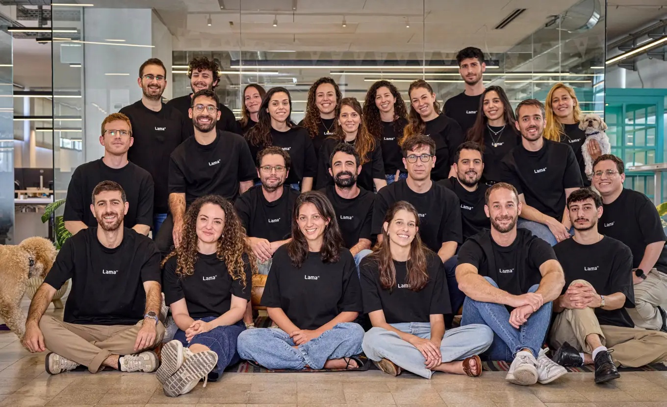 Lama AI team in matching black shirts in an office, accompanied by two dogs