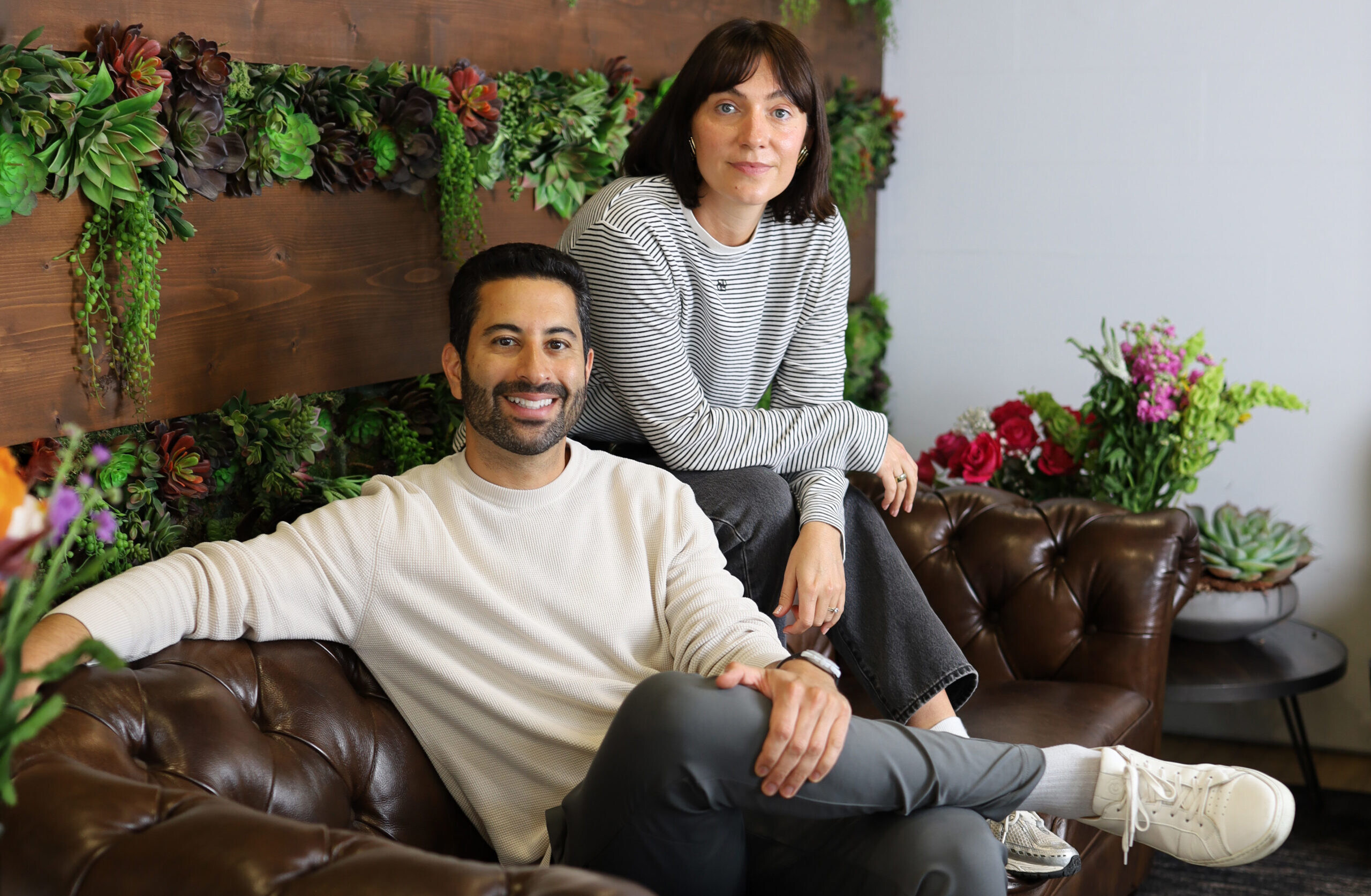 BloomNation co-founder Farbod Shoraka seated beside Floom founder Lana Elie in a flower-filled room