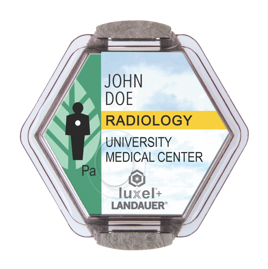 A hexagonal LANDAUER Luxel+ radiation dosimeter with its printed identification label