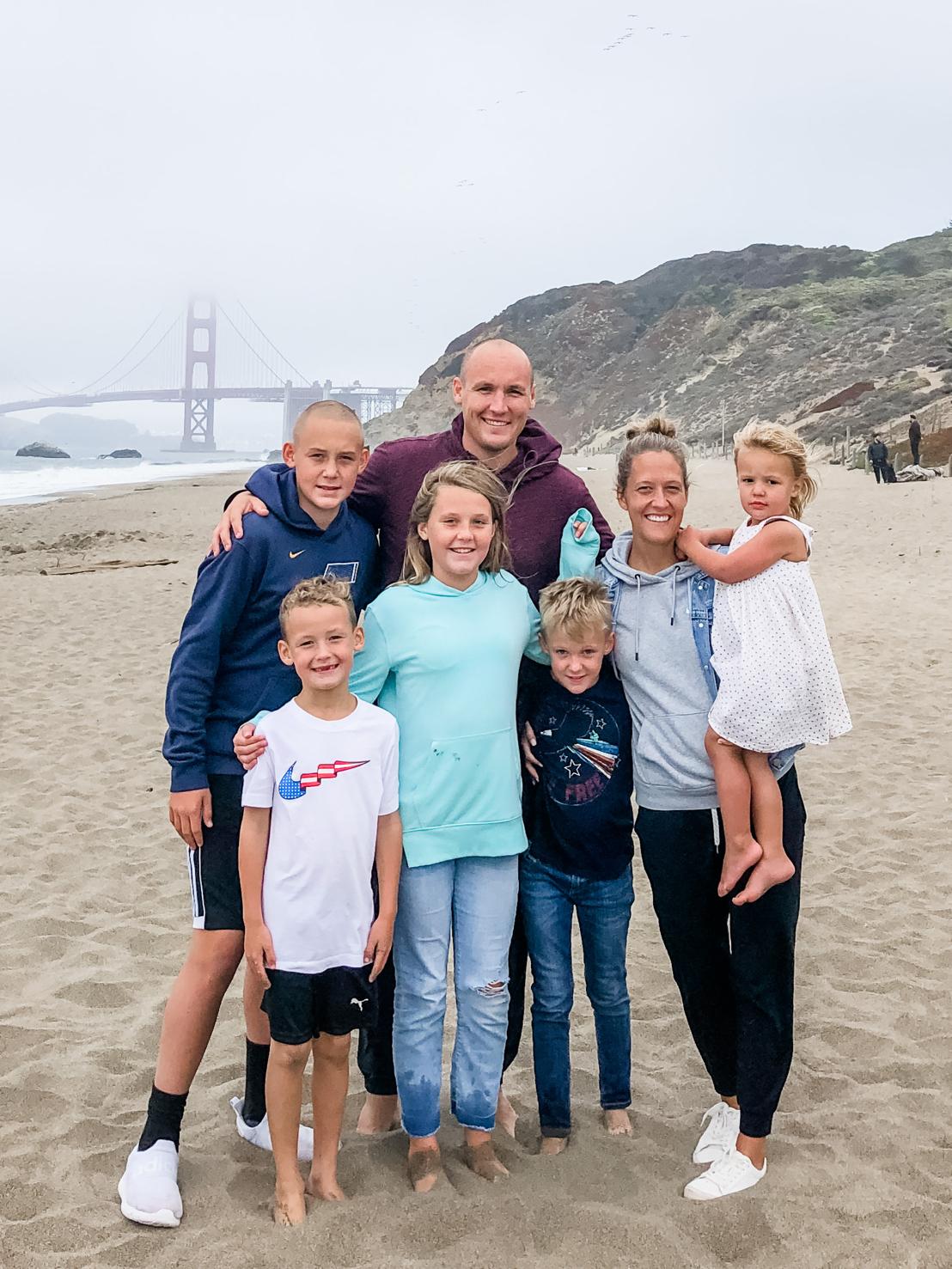 Landon Taylor and his wife, Kelsi, with their five children on a beach near the Golden Gate Bridge