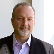 Archival portrait of Larry Davis wearing a dark jacket and purple shirt