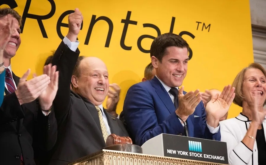 Larry Silber raises his arm alongside colleagues at the New York Stock Exchange in July 2016