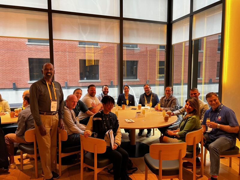 Conference participants gathered around a round table at MACH X in Toronto