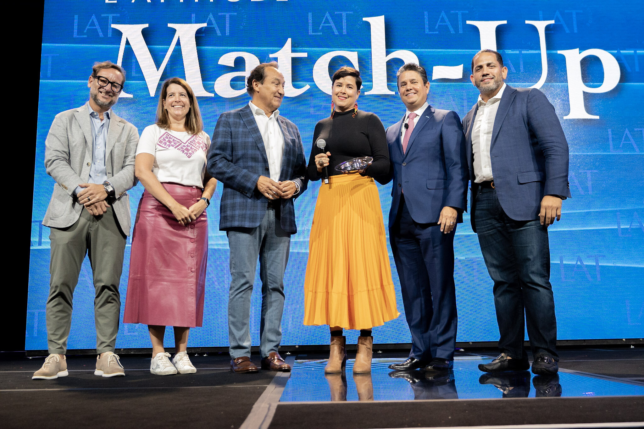 Nopalera founder Sandra Velasquez holding her award with Oscar Munoz and finance executives at Match-Up in 2022