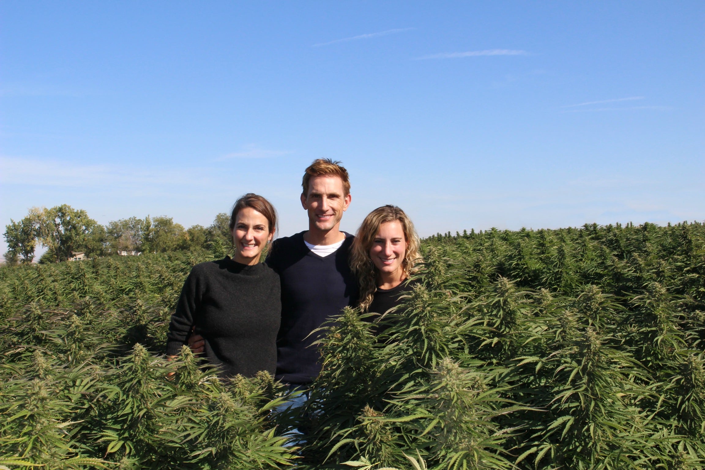 Laurel Angelica Myers, Christopher Gavigan, and Jessica Assaf standing together on an Oregon hemp farm
