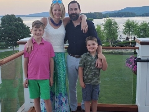 Lauren Banyar Reich with her husband Carter and their two sons beside a lake