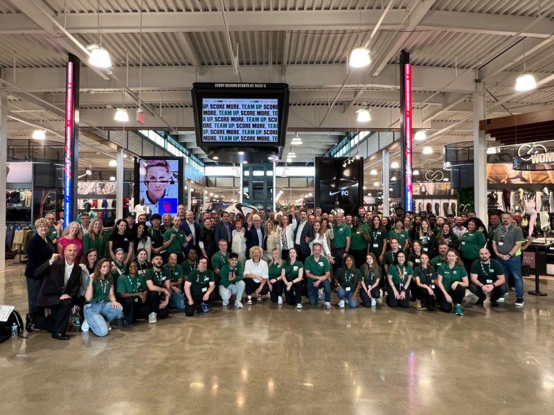 Lauren Hobart with a large group of DICK’S teammates inside a sporting-goods store