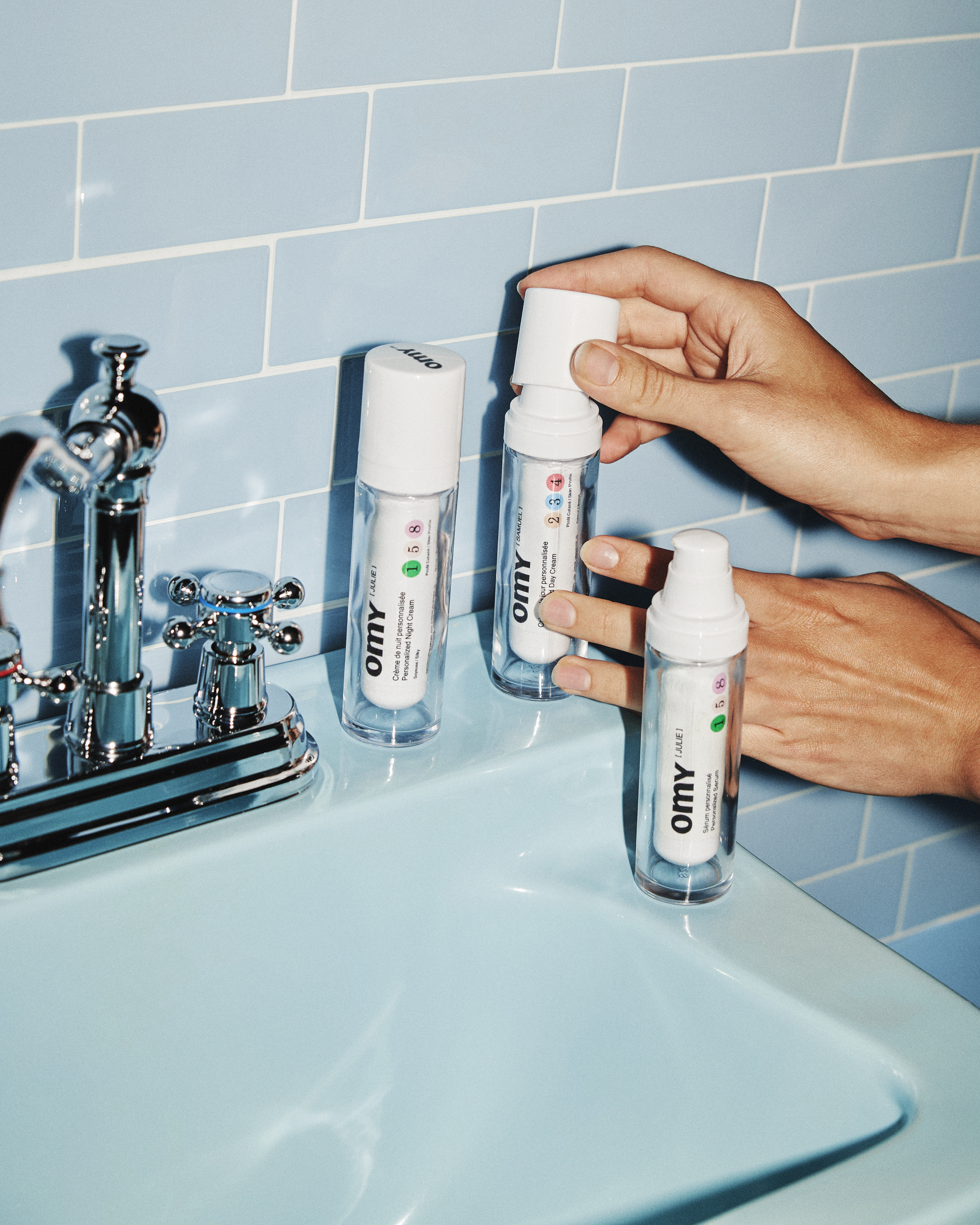 Omy personalized products arranged beside a blue-tiled sink