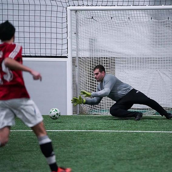 Laurence Girard in goal for Sporting SC, reaching toward the ball