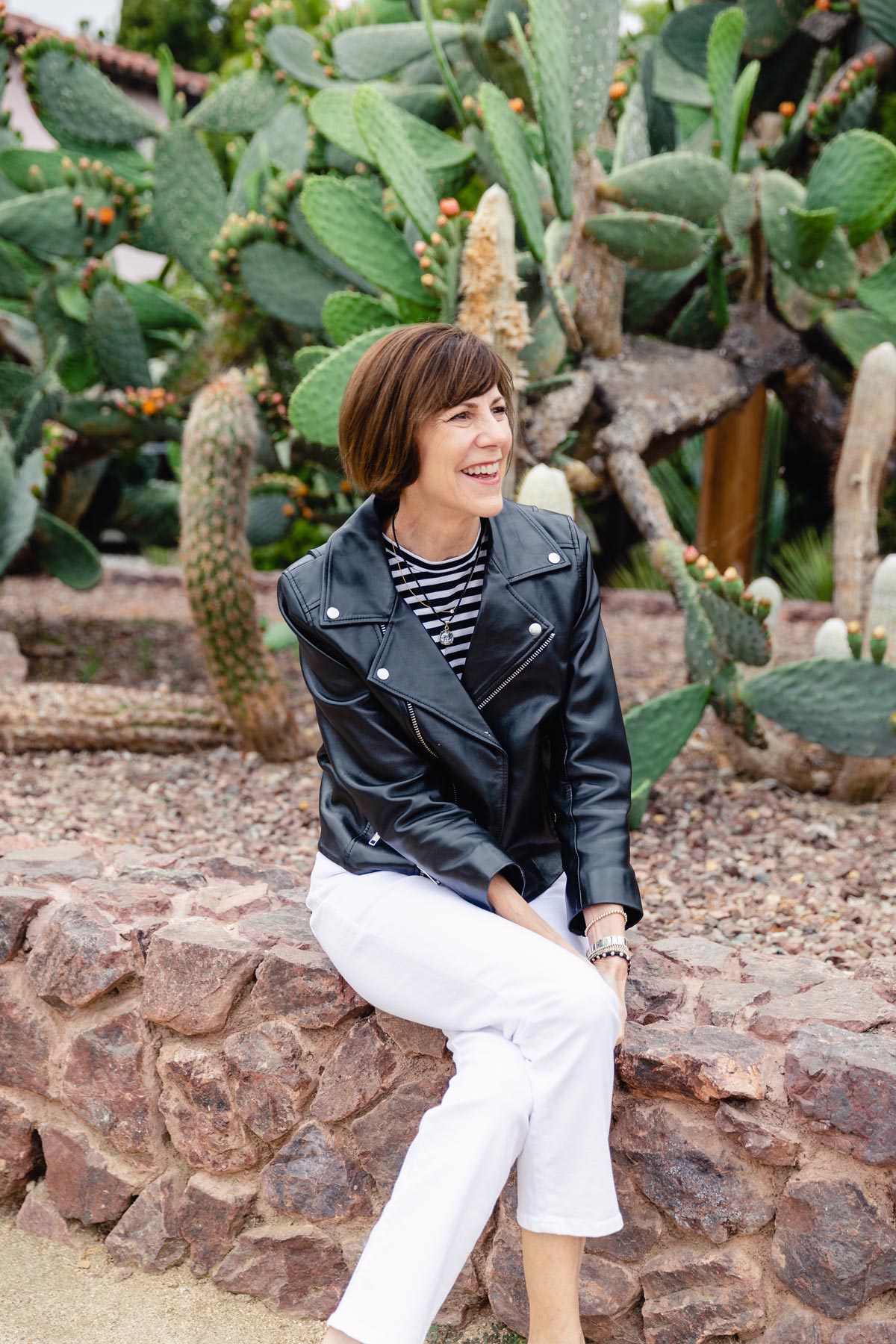 Laurie Buckle smiling while seated outdoors beside a cactus garden