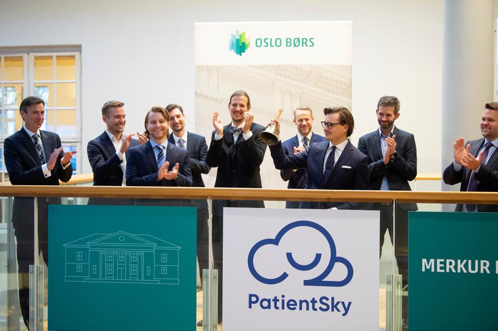 Laust Wilster Axelsen holding a bell alongside PatientSky colleagues during its listing period