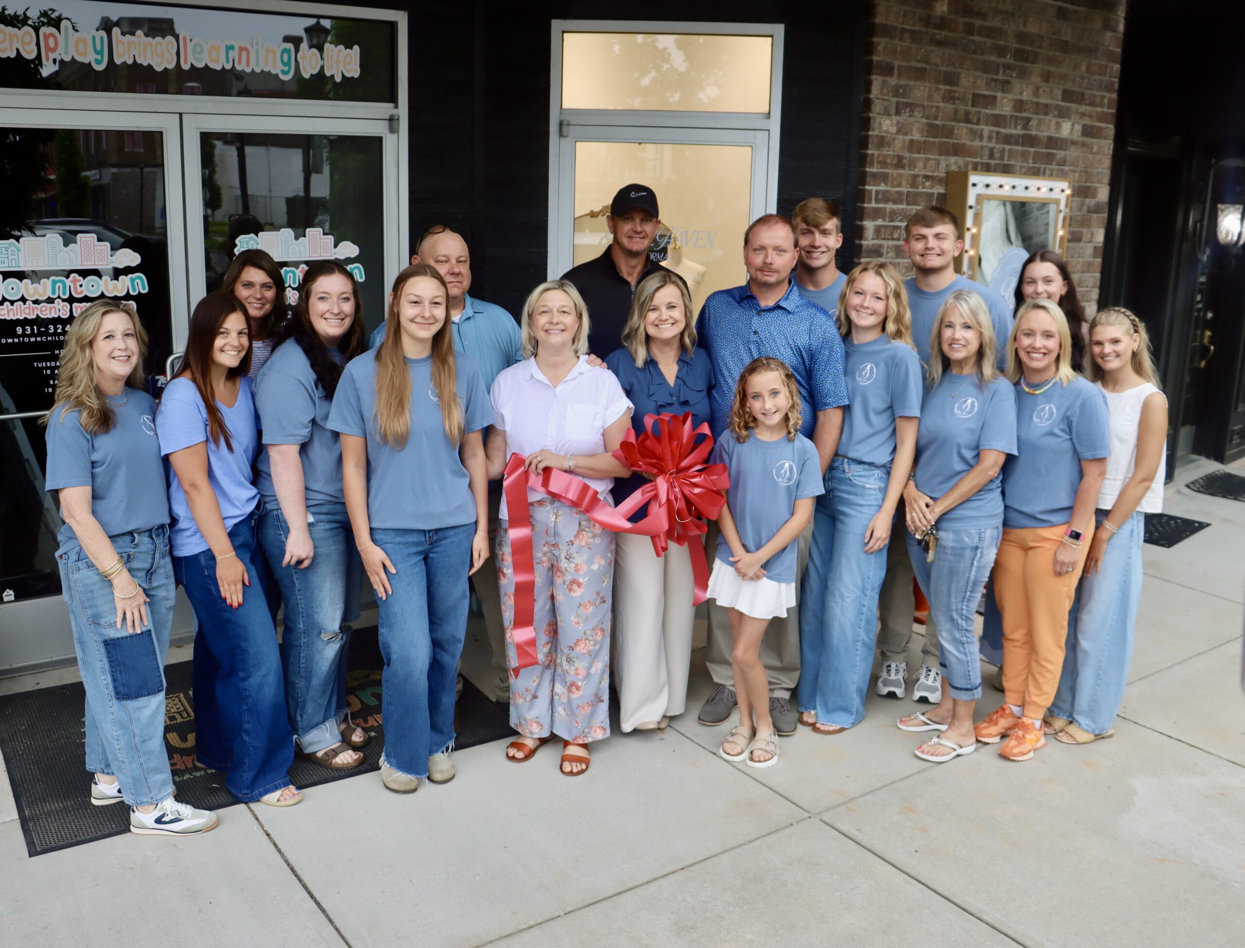 A group of people gathers outside a Lawrenceburg business for a ribbon cutting