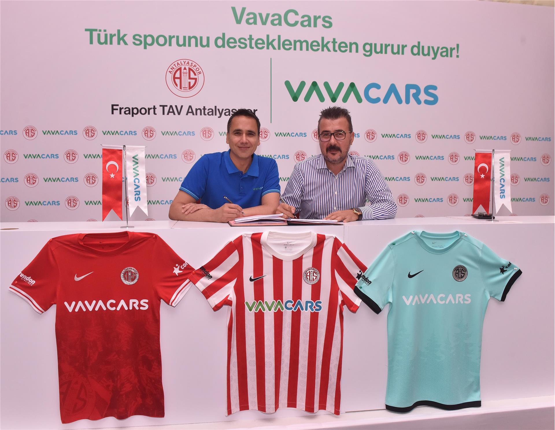 Lawrence Merritt and Antalyaspor president Aziz Çetin signing the sponsorship agreement behind three football shirts