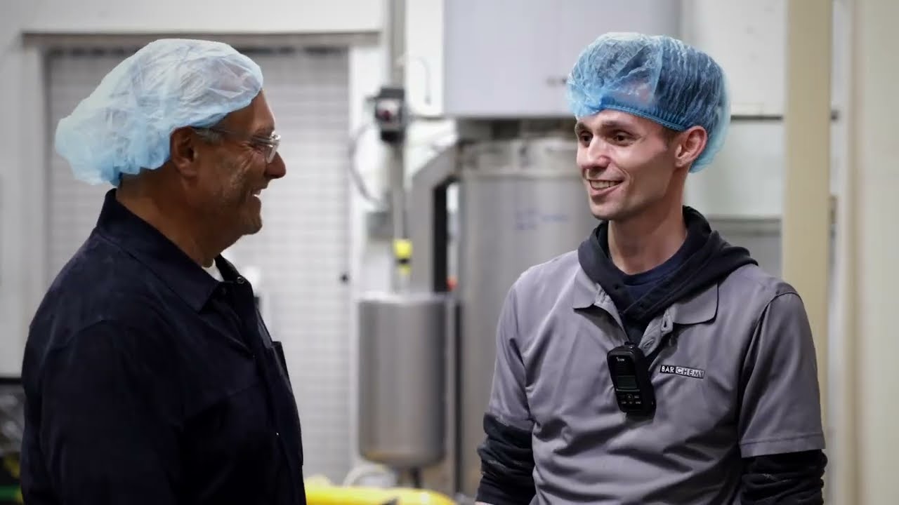Larry Toscano speaking with a Barchemy colleague on the production floor